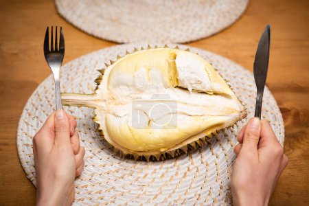 Téléchargez les photos : Durian et les mains avec couteau et fourchette - en image libre de droit