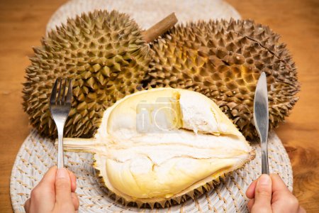 Téléchargez les photos : Durian et les mains avec couteau et fourchette - en image libre de droit