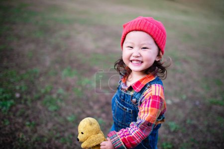 Photo for Little asian girl with teddy bear  in park. - Royalty Free Image