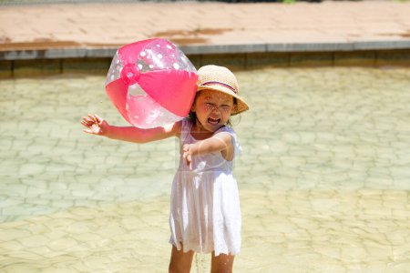 Photo for Girl playing in the pool with ball - Royalty Free Image