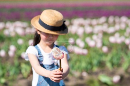 Foto de Lindo asiático chica posando con tulipanes en el campo - Imagen libre de derechos