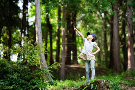 Photo for Girl pointing to the sky in the woods - Royalty Free Image