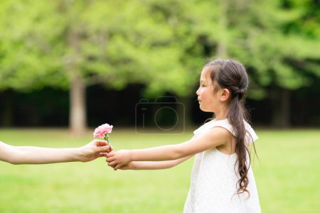 Photo for Pretty girl handing pink carnation - Royalty Free Image