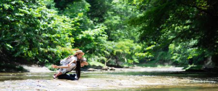Téléchargez les photos : Mère et enfant jouant dans la rivière - en image libre de droit
