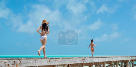 Téléchargez les photos : Mère et fille courant sur la plage - en image libre de droit
