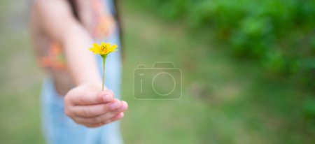 Foto de Chica sostener una flor amarilla - Imagen libre de derechos