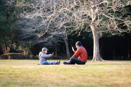 Foto de Padre e hija jugando en un parque en invierno - Imagen libre de derechos