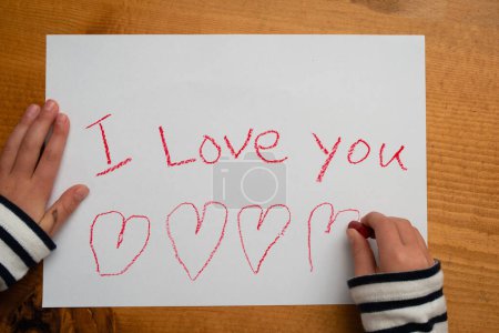 Foto de Niño que escribe Te amo en papel - Imagen libre de derechos