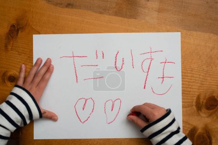 Téléchargez les photos : Enfant qui écrit Je t'aime en japonais sur papier - en image libre de droit