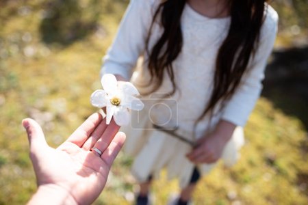 Parent and child handing white flower