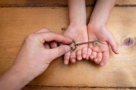 Parent and child hands handing key