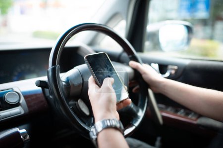Foto de Conducción manual masculina mientras opera un teléfono inteligente - Imagen libre de derechos