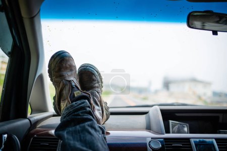 Photo for Man raising their feet in the passenger seat of a car - Royalty Free Image