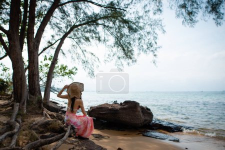 Téléchargez les photos : Jeune femme près de la mer regardant au loin - en image libre de droit