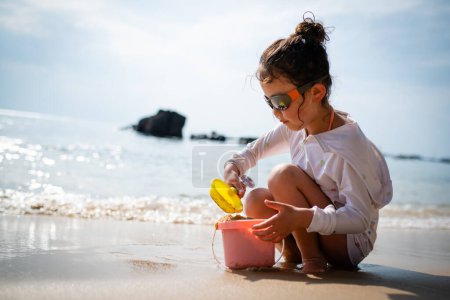 Photo for A girl playing sand at the beach - Royalty Free Image
