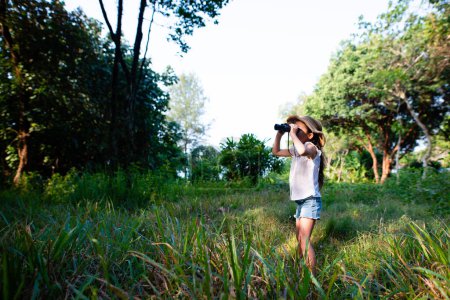 Photo for Girl using binoculars in the jungle - Royalty Free Image