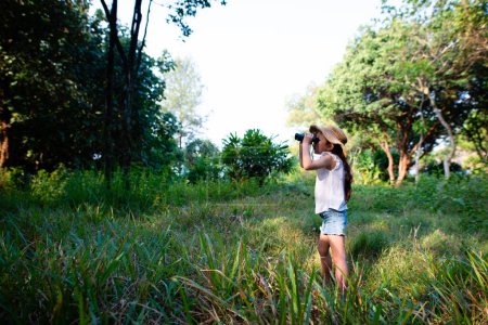 Foto de Asiático niña mirando a través de binoculares al aire libre - Imagen libre de derechos
