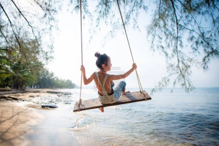 Foto de Chica jugando en swing en la playa - Imagen libre de derechos