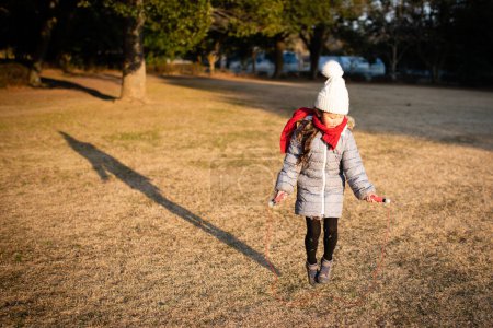 Téléchargez les photos : Petite fille avec corde à sauter dans le parc. - en image libre de droit