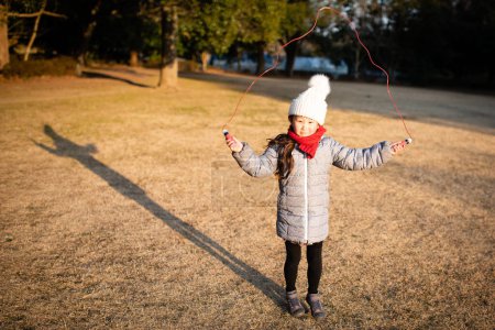 Téléchargez les photos : Fille jouer avec saut corde - en image libre de droit