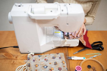 Photo for Young woman  sewing on machine, workshop - Royalty Free Image