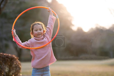 Photo for Asian woman with hula hoop in the park - Royalty Free Image