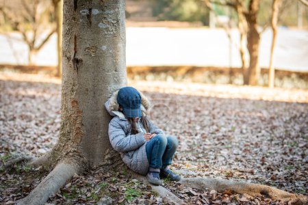 Photo for Girl to rest leaning against a tree - Royalty Free Image