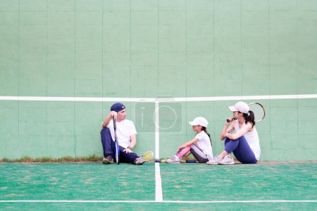 Foto de Padre y madre e hija a la práctica del tenis - Imagen libre de derechos