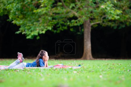 Téléchargez les photos : Fille ayant un pique-nique sur la pelouse - en image libre de droit