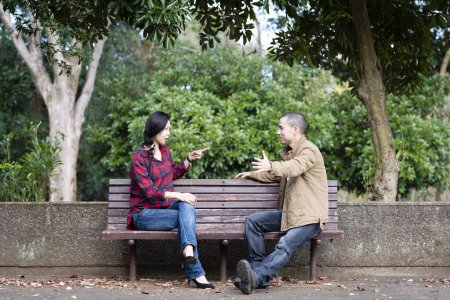 Téléchargez les photos : Jeune couple sur un banc dans le parc - en image libre de droit