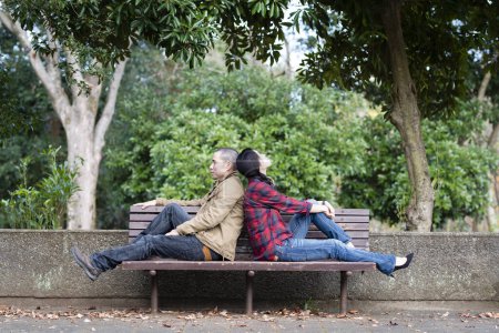 Téléchargez les photos : Couple assis sur un banc de parc - en image libre de droit