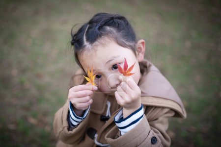 Photo for Asian girl with leaves in autumn park - Royalty Free Image