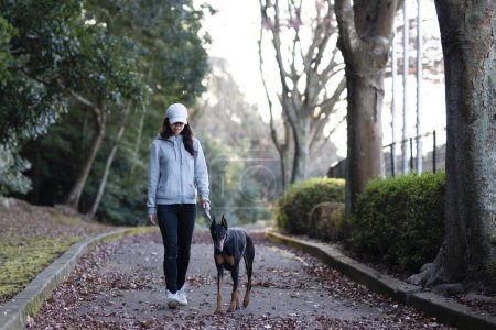 Foto de Mujer caminando con un perro - Imagen libre de derechos