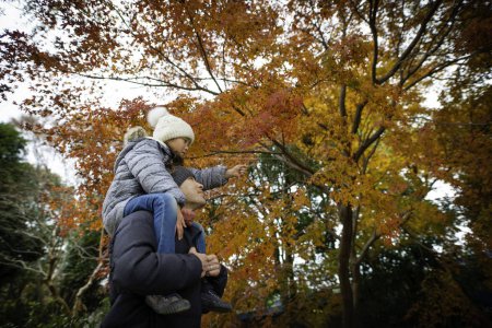 Téléchargez les photos : Père et fille regardant les feuilles d'automne - en image libre de droit
