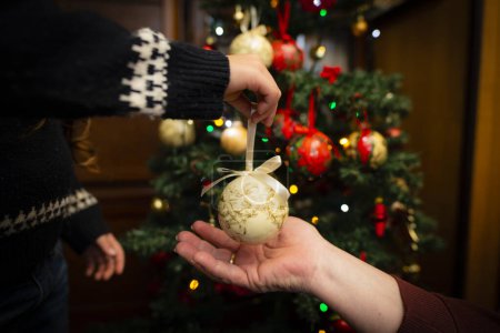 Téléchargez les photos : Les mains de petite-fille et grand-mère sur la décoration de l'arbre de Noël - en image libre de droit