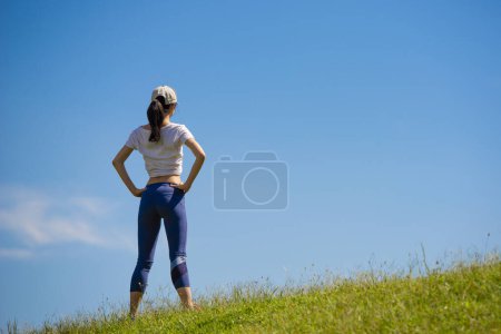 Téléchargez les photos : Belle femme debout sur la pelouse un jour d'été - en image libre de droit