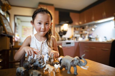 Foto de Chica arreglando juguetes de animales - Imagen libre de derechos