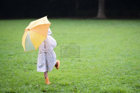 Téléchargez les photos : Fille marche avec un parapluie un jour de pluie - en image libre de droit