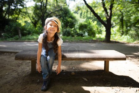 Photo for Girl sitting on a bench - Royalty Free Image