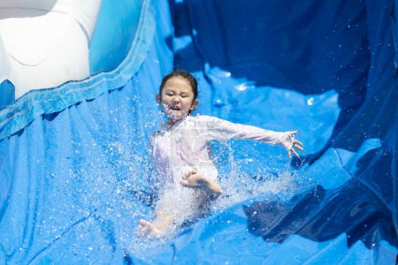 Photo for Girl playing with a waterslide - Royalty Free Image