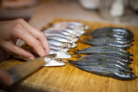 Téléchargez les photos : Cuisson à la main sardines à table - en image libre de droit