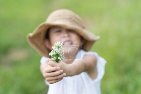 Photo for Child with flowers in field - Royalty Free Image