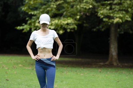 Foto de Estómago de mujer hermosa en el parque - Imagen libre de derechos