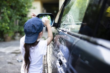 Téléchargez les photos : Petite fille laver la voiture - en image libre de droit