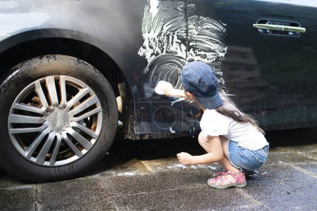 Téléchargez les photos : Petite fille laver la voiture - en image libre de droit