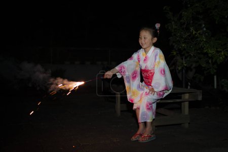 Téléchargez les photos : Fille jouer avec des feux d'artifice - en image libre de droit