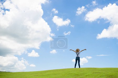 Photo for Woaman  in  hat with hands up  standing on green grass - Royalty Free Image