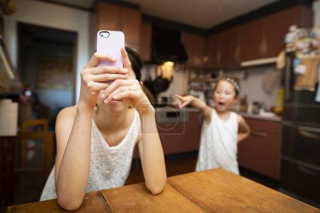 Téléchargez les photos : Fille en colère contre la mère pour utiliser le téléphone intelligent - en image libre de droit