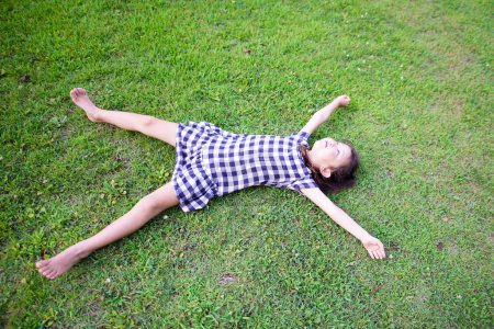 Téléchargez les photos : Fille s'allonger sur la pelouse - en image libre de droit