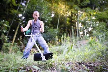 Photo for Man mow the weeds - Royalty Free Image